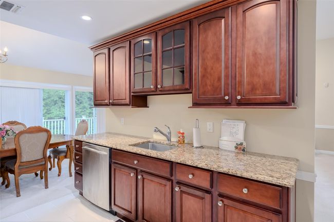 Kitchen featuring dishwasher, light stone countertops, glass insert cabinets, and recessed lighting | Image 15