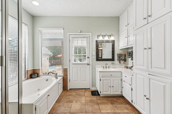 Full bath featuring a tub with jets, a textured ceiling, and vanity | Image 19