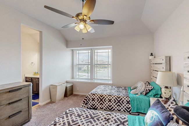 Bedroom featuring lofted ceiling, baseboards, a ceiling fan, light carpet, and ensuite bathroom | Image 18