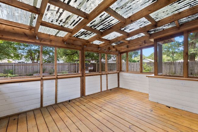 Step out onto the screened-in porch—crafted with a warm wood finish and translucent roofing that filters the light just right! | Image 32