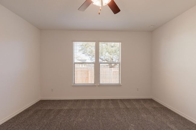Empty room featuring baseboards, dark carpet, ceiling fan, and a wealth of natural light | Image 27