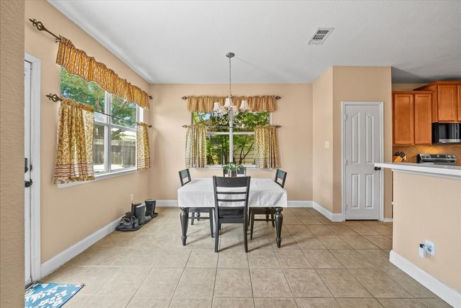 Dining area with a chandelier, light tile patterned floors, and baseboards | Image 19