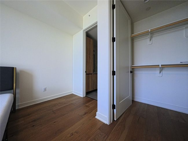 Unfurnished bedroom with hardwood / wood-style flooring and baseboards | Image 7