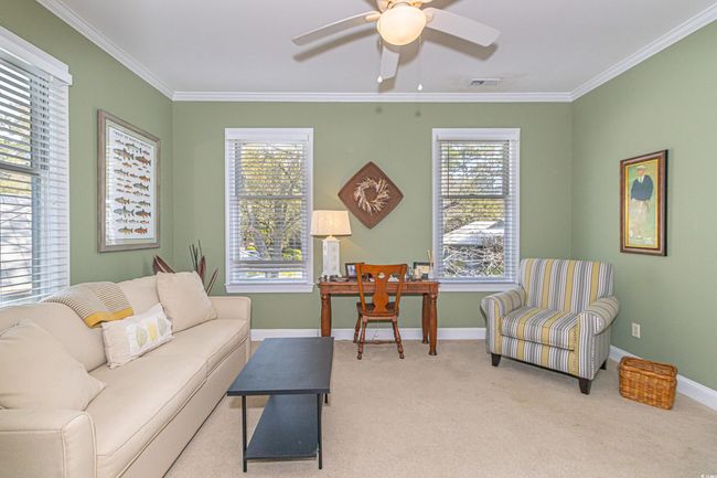 Carpeted living area with baseboards, ornamental molding, visible vents, and ceiling fan | Image 28