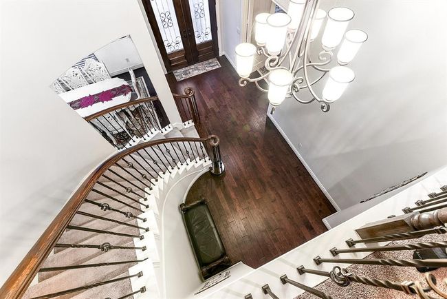 This upstairs view offers a grand perspective overlooking the foyer, showcasing its impressive design and open, airy feel. The high ceilings and elegant staircase create a striking focal point. | Image 41