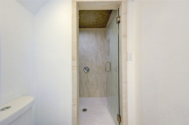 Bathroom featuring toilet and a stall shower | Image 16
