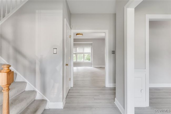 Foyer entrance with stairwell to second floor, hallway to great room, and formal dining room to the right | Image 6