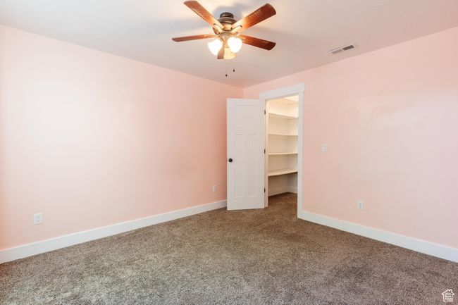 Carpeted empty room with a ceiling fan and baseboards | Image 34