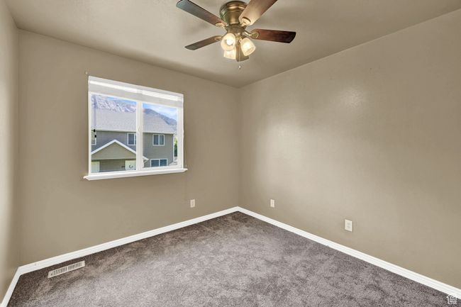 Carpeted empty room with baseboards and a ceiling fan | Image 17