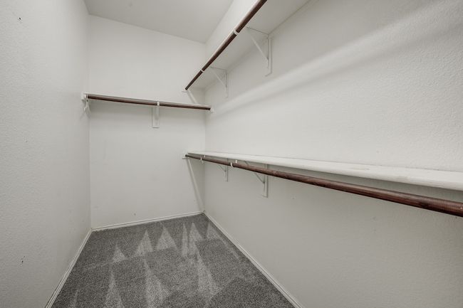 Spacious closet featuring dark colored carpet | Image 24