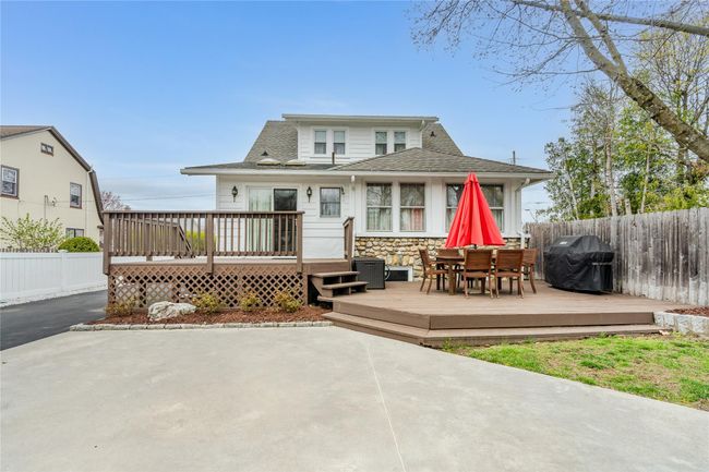 Back of house with fence, a wooden deck, a patio area, and stone siding | Image 37