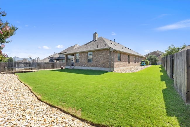 Generously sized, level backyard with a lush lawn and . | Image 34
