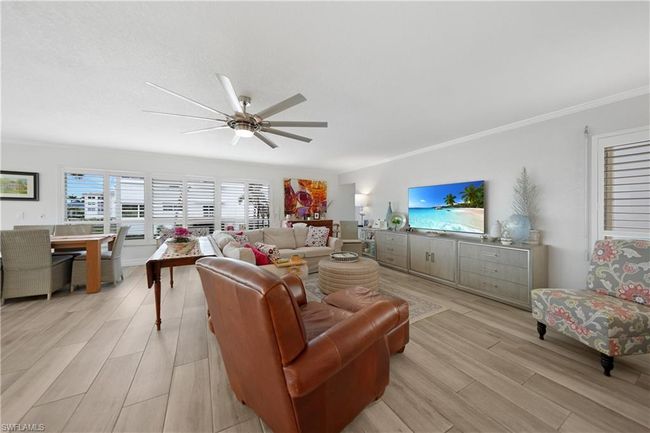 Living room with ceiling fan, light wood-type flooring, and ornamental molding | Image 13