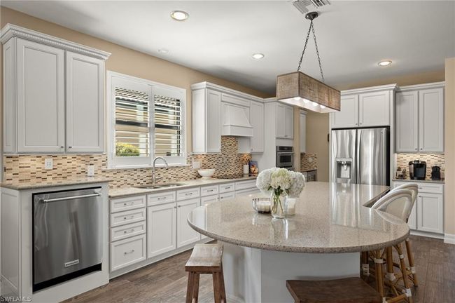 Kitchen featuring pendant lighting, white cabinetry, sink, and appliances with stainless steel finishes | Image 10