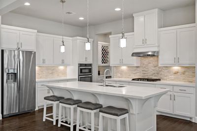 Kitchen with sink, dark hardwood / wood-style flooring, backsplash, and stainless steel appliances | Image 1