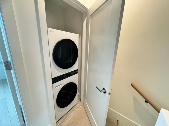 Laundry area featuring stacked washer and dryer, light tile patterned floors, and laundry area | Image 37