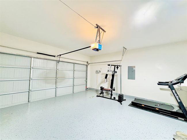 Garage featuring a garage door opener and electric panel | Image 30