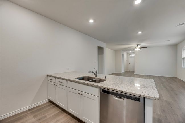 Kitchen featuring dishwasher, a sink, a peninsula, light wood finished floors, and a ceiling fan | Image 20