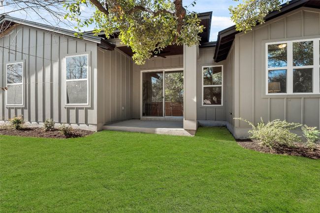 Rear view of house featuring board and batten siding, a yard, and a patio | Image 28