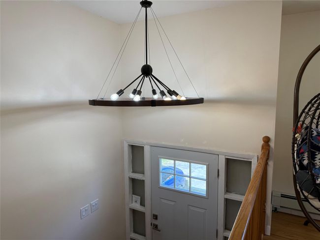 Room details with a baseboard radiator and a notable chandelier | Image 5