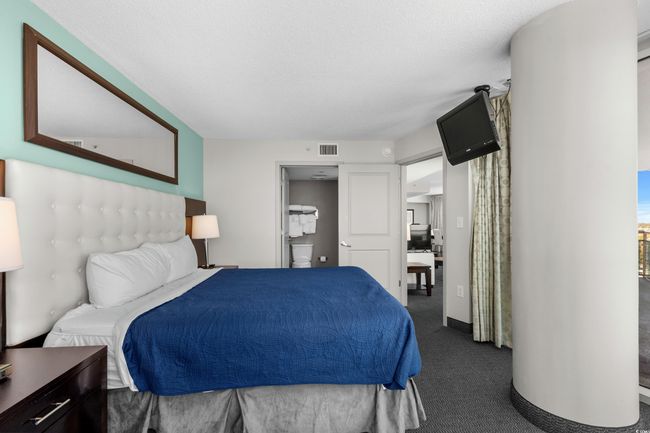 Bedroom featuring visible vents and dark carpet | Image 19