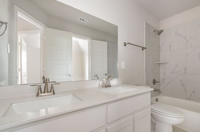 Bathroom featuring double vanity, tub / shower combination, and toilet | Image 28