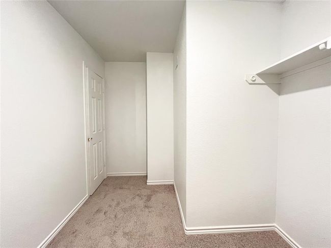 Spacious carpeted walk-in closet for ultimate storage and comfort. | Image 17