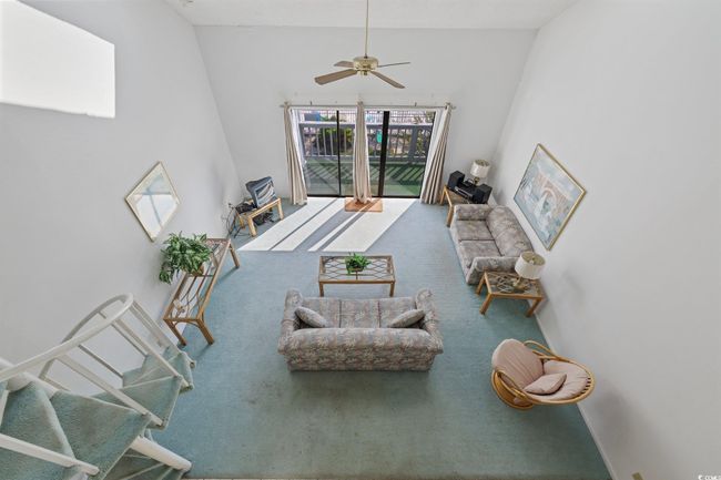 Carpeted living area with ceiling fan and high vaulted ceiling | Image 17