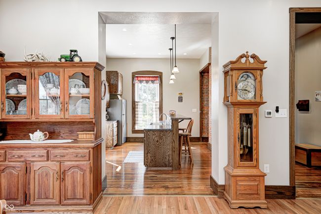 kitchen with light wood-style floors, freestanding refrigerator, glass insert cabinets, and a kitchen breakfast bar | Image 19
