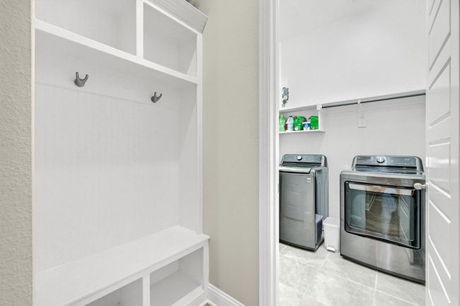 Clothes washing area with laundry area, baseboards, light tile patterned floors, and washer and dryer | Image 22