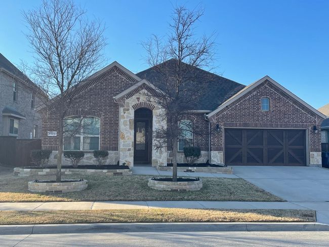 French country inspired facade featuring stone siding, brick siding, and driveway | Image 5