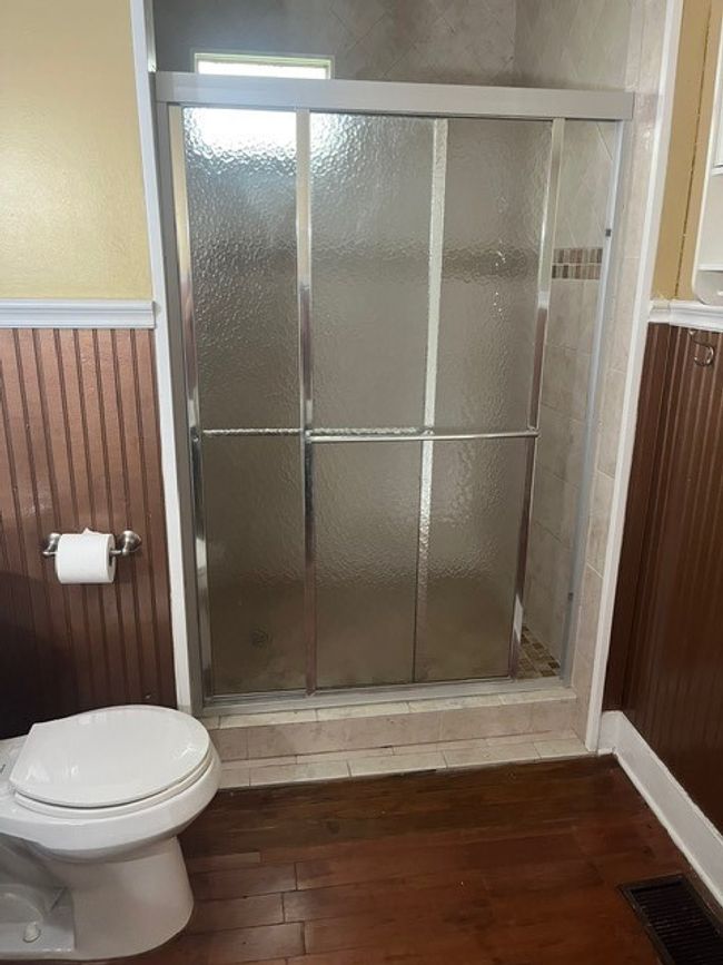 Bathroom with hardwood / wood-style floors, a stall shower, and wainscoting | Image 22