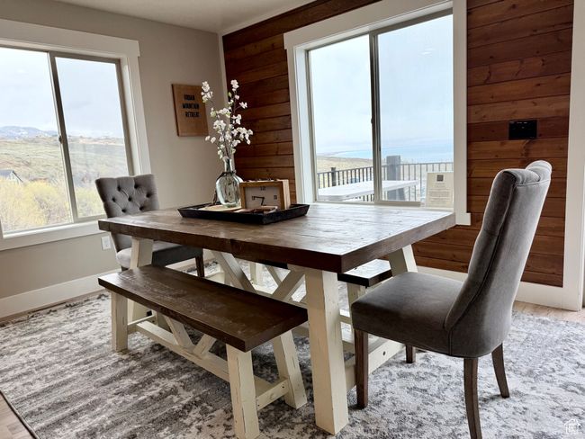 Dining area with wooden walls, baseboards, and light wood finished floors | Image 24