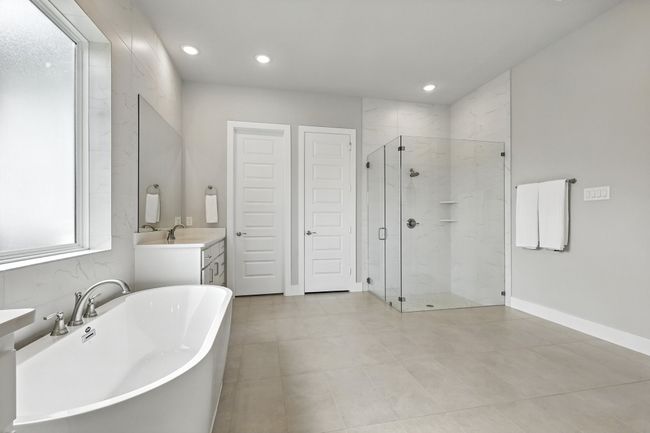 Bathroom with a soaking tub, a marble finish shower, vanity, recessed lighting, and tile patterned flooring | Image 16