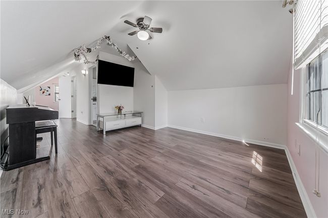 Bonus room with dark wood-style floors, vaulted ceiling, baseboards, and a ceiling fan | Image 27
