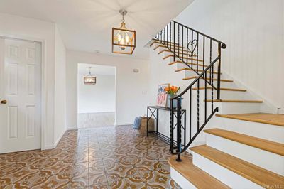 Stairway featuring an inviting chandelier and tile patterned floors | Image 3