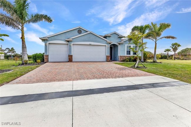 View of front of house with an attached garage, a front yard, stucco siding, and decorative driveway | Image 43