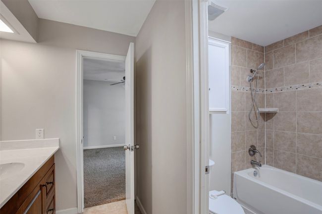 Bathroom featuring toilet, baseboards, shower / bathing tub combination, and vanity | Image 13