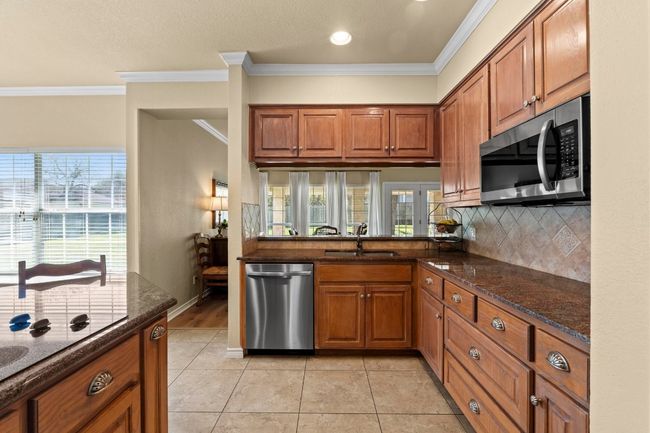 Kitchen featuring brown cabinets, stainless steel appliances, and a sink | Image 11