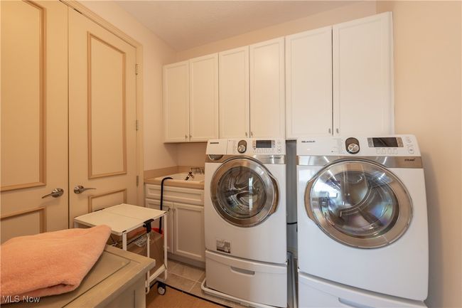 Laundry room located off sitting area in primary suite. | Image 37
