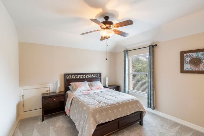 Bedroom with light carpet, baseboards, ceiling fan, and vaulted ceiling | Image 31