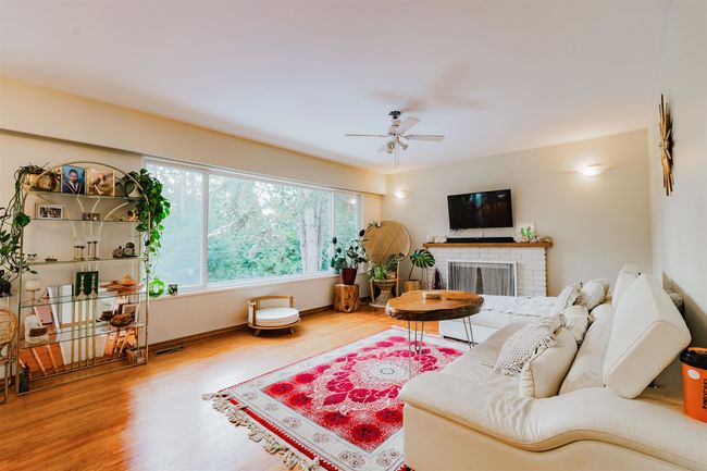 Living area featuring baseboards, a brick fireplace, wood finished floors, and ceiling fan | Image 6