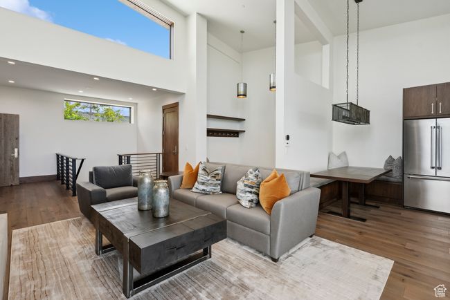 Living area with a high ceiling, wood finished floors, and recessed lighting | Image 89