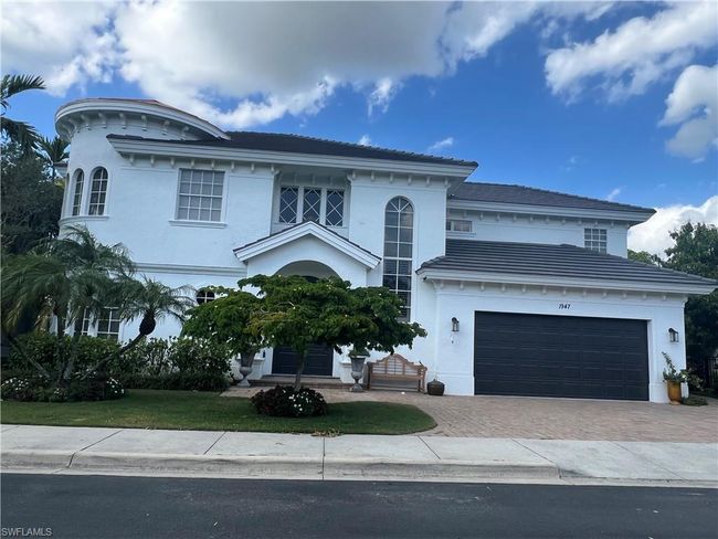 View of front of home with decorative driveway, an attached garage, and stucco siding | Image 37