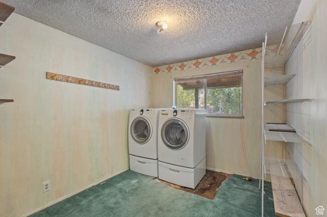 Laundry room/Bedroom featuring washer and dryer, a textured ceiling, and carpet | Image 20
