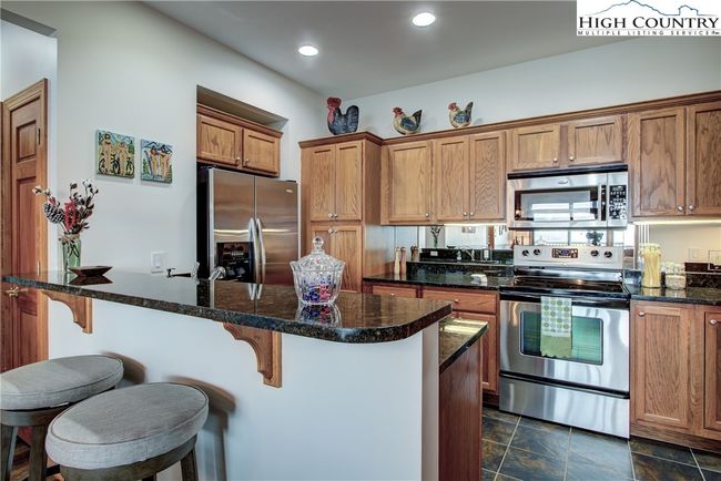 You will love this Chef's kitchen with its ceramic tile flooring, granite counter tops and stainless appliances. | Image 23