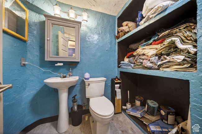 Half bathroom featuring a textured wall and toilet | Image 13