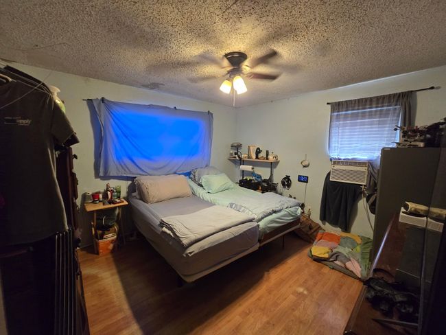 Bedroom with wood finished floors, a textured ceiling, and ceiling fan | Image 21