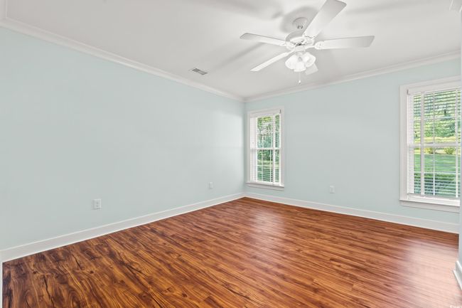 Spare room featuring ornamental molding, plenty of natural light, dark wood-style floors, and a ceiling fan | Image 16