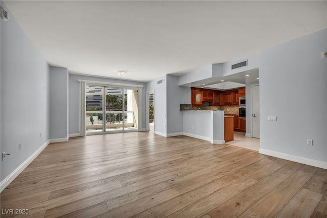 Unfurnished living room with light wood-type flooring, baseboards, and visible vents | Image 7